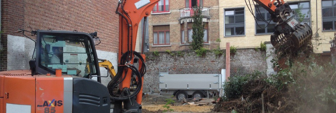 Een graafmachine verwijdert struiken tijdens de aanleg van een tuin